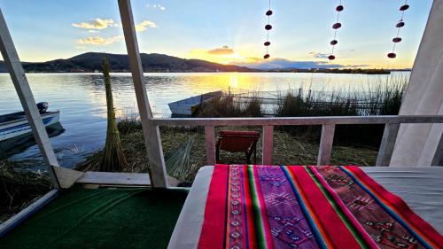 a bed on a porch with a view of a lake at Uros titikaka Golden Lodge in Puno