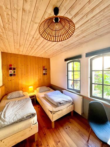 a bedroom with two beds and a ceiling with a chandelier at A L’Abri Du Loup in Roquefort-sur-Garonne
