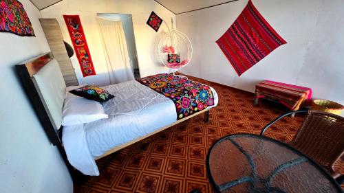 a bedroom with a bed and a table and a chair at Uros titikaka Golden Lodge in Puno