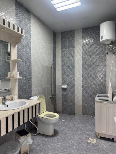 a bathroom with a toilet and a sink at استراحة الصقر in Khor Fakkan