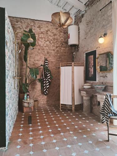 a room with a brick wall with a checkered floor at Casa Barreres in Moncada