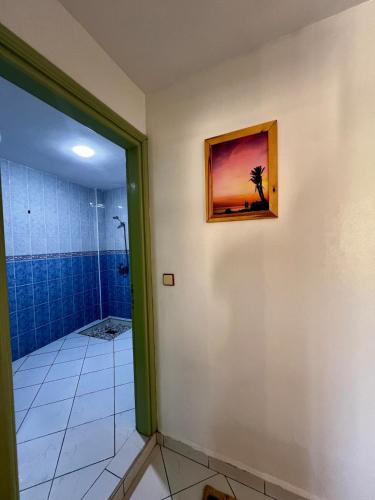 a bathroom with a shower and a painting on the wall at Cozy Flat With Pool Near The Beach TAMRAGHT -APP13 in Tamraght Ouzdar