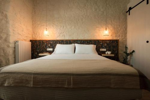 a bedroom with a large bed with two tables at UMA Rural Boutique - La Garrotxa in Mieras