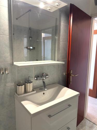 a bathroom with a white sink and a mirror at Apartments Ema in Sali