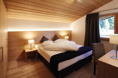 1 dormitorio con 1 cama grande y techo de madera en Appartementhaus Sonnenhang, en Ehrwald