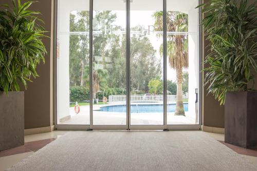 an empty room with a sliding glass door looking out at a pool at Hotel Pradillo Conil in Conil de la Frontera