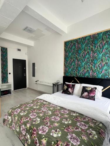 a bedroom with a large bed with a green wall at Studio Factory 22 in Braşov