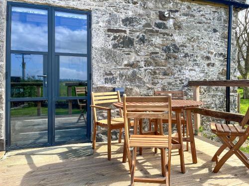a wooden table and chairs on a deck at Landberrick Farm Bothy 2 in Newton Stewart