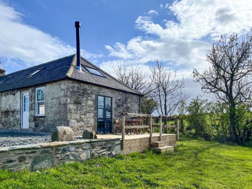a stone house with a fence in front of it at Landberrick Farm Bothy 2 in Newton Stewart