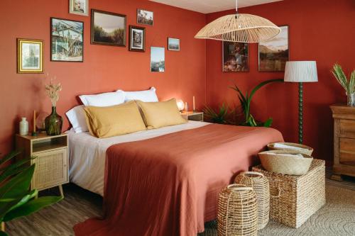 a bedroom with a large bed with orange walls at Hôtel Latécoère in Biscarrosse