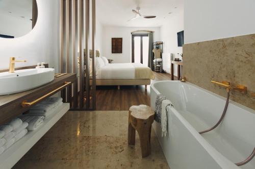 a bathroom with a tub and a sink and a bed at UMA Rural Boutique - La Garrotxa in Mieras