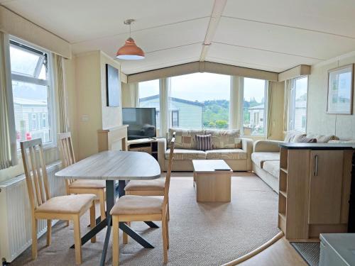 a living room with a table and a couch at Forest Edge - Uk51739 in Oakmere