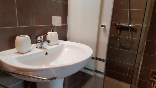 een witte wastafel in een badkamer met een douche bij Exclusive Apartments in center in Mistretta