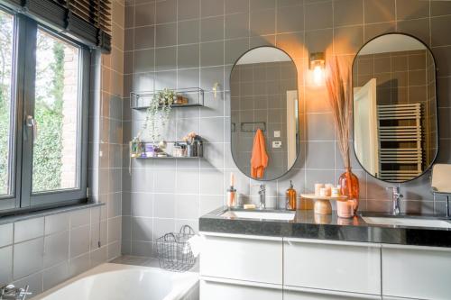 ein Badezimmer mit zwei Waschbecken und zwei Spiegeln in der Unterkunft Weynhoven in Brecht