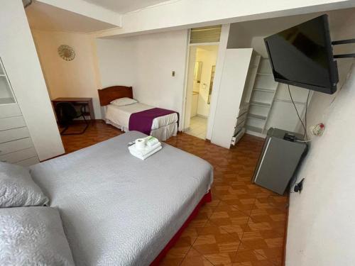a hotel room with two beds and a flat screen tv at Zigal hotel in Antofagasta