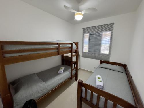 two bunk beds in a room with a ceiling fan at San Martin in Bertioga