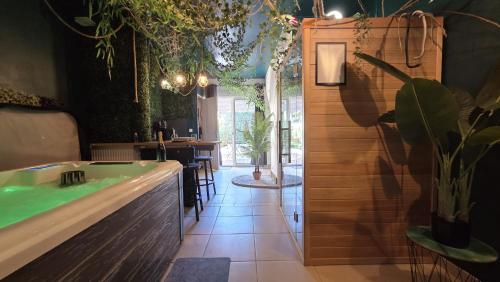 a bar with a tub in a room with plants at Botanica - Private Spa in Saint-Quentin