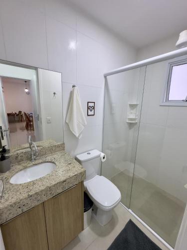 a bathroom with a toilet and a sink and a shower at San Martin in Bertioga