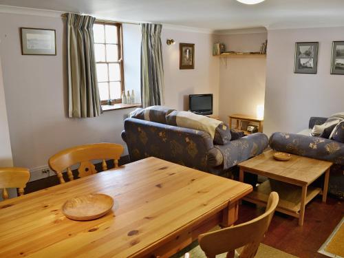 a living room with a table and a couch at Haven Cottage - E4342 in Holy Island