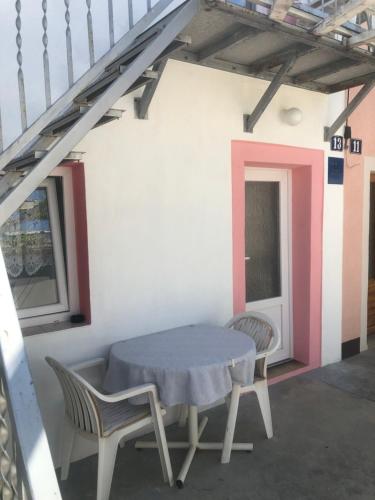 a table and chairs in a room with a staircase at Appartement Studio 1 Punat Insel Krk in Punat