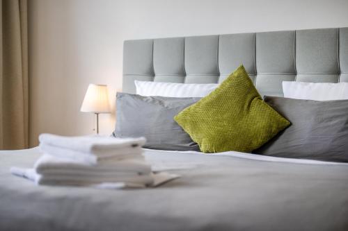 a bed with a yellow pillow and a stack of books at Appartements an der Therme in Bad Ems