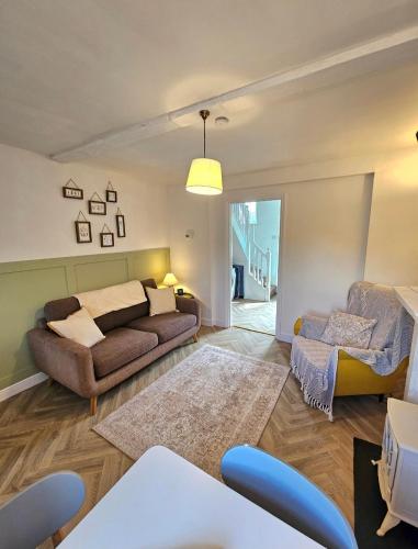 a living room with a couch and a table at Holly Cottage in Edwinstowe