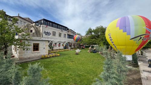 two hot air balloons are flying over a yard at Cappanar Cave in Nar