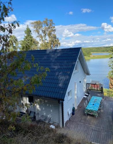 ein Haus mit Terrasse und Blick aufs Wasser in der Unterkunft Mälarvilla in Strängnäs