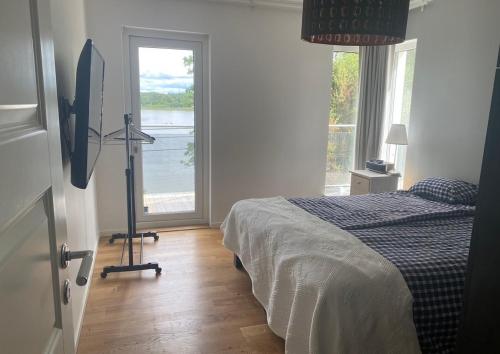 ein Schlafzimmer mit einem Bett und einem großen Fenster in der Unterkunft Mälarvilla in Strängnäs