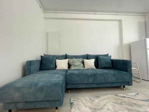 a blue couch sitting in a living room at Apartament Madagascar Hotel BS by Ella Mamaia Nord in Mamaia Sat/Năvodari