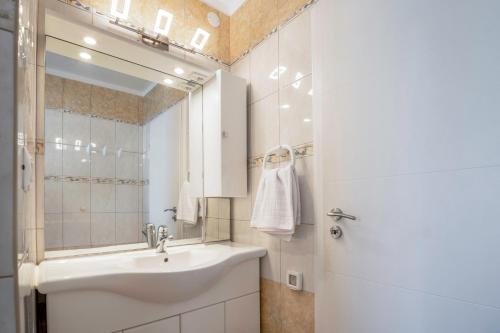 a white bathroom with a sink and a mirror at Prostorni in udobni apartmaji Izola SL - Spacious & Comfortable Apartments Izola SL in Izola