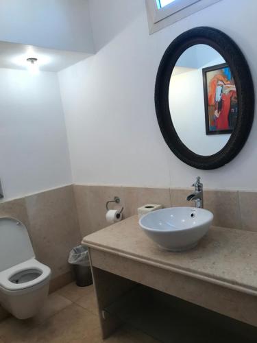 a bathroom with a sink and a toilet and a mirror at Carlton Luxury Villa in Sharm El Sheikh