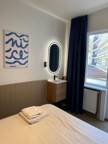 a bedroom with a bed and a sink and a window at Residentie Sweetnest met hotelservice à la carte - 3 dubbel kamers in Knokke-Heist