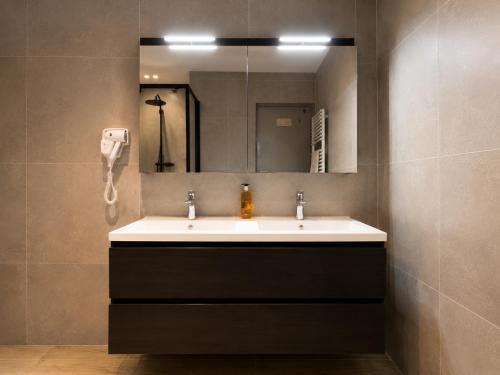 a bathroom with a sink and a mirror at Residentie Sweetnest met hotelservice à la carte - 3 dubbel kamers in Knokke-Heist