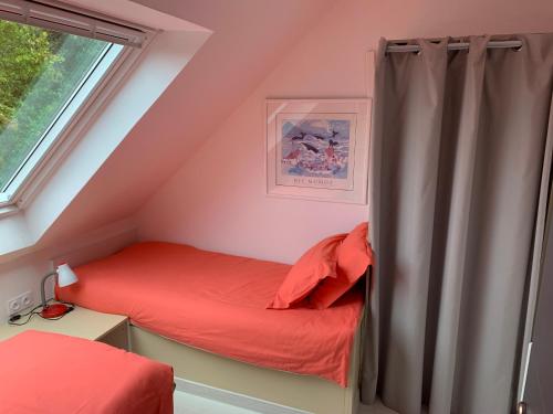 a small attic bedroom with a bed and a window at Gite Gavotte in Concarneau
