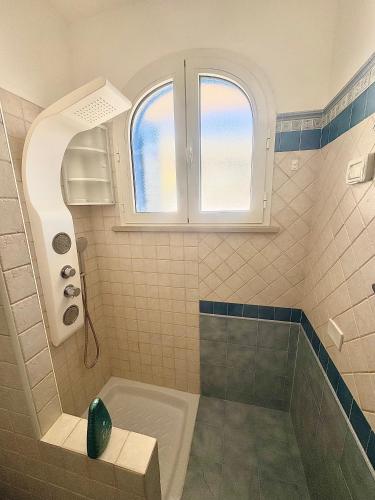 a bathroom with a tub and a shower with a window at B&B Santa Maria Di Leuca in Leuca