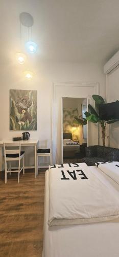a bedroom with two beds and a desk and a table at Room Lui, sa besplatnim parkingom in Rijeka
