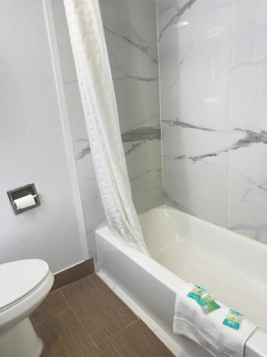 a bathroom with a white tub and a toilet at Bourne Bridge Inn Former Eastern Inn in Bourne
