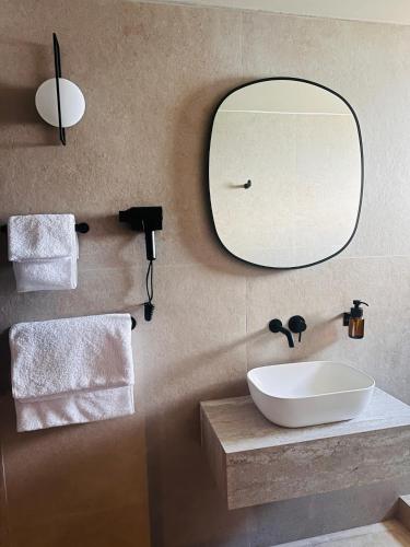 a bathroom with a sink and a mirror on the wall at Hotel Ti' Pelican in Saint-Pierre