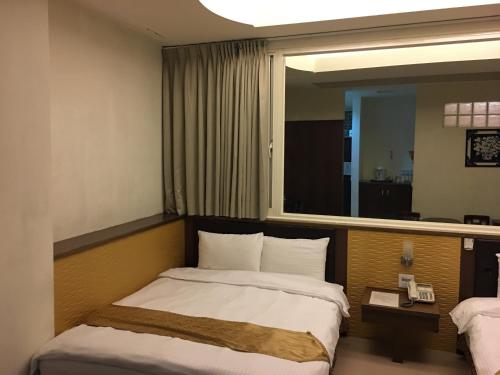 a hotel room with a bed and a mirror at Ri Yue Hu Pan Resort in Yuchi