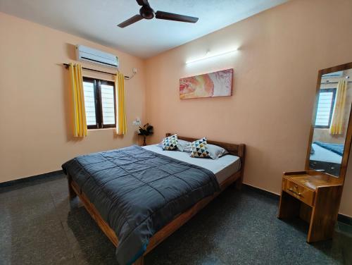 a bedroom with a bed and a ceiling fan at Hamsa Farmstay - 2BHK AC Homestay in Mysore