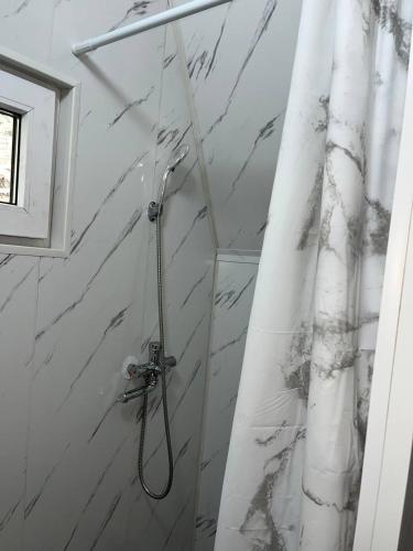 a bathroom with a shower with a shower curtain at A frame house with a view of mountains in Karakol