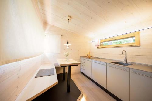 a small kitchen with a sink and a table at berge I Design-Quartiere in Aschau im Chiemgau