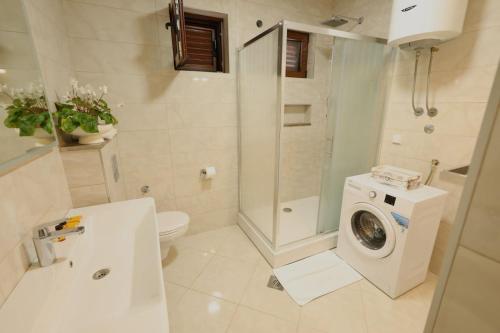 a bathroom with a washing machine and a toilet at Sea Nook in Trstenik