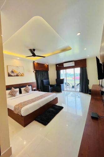 a bedroom with a large bed with a ceiling fan at The Cristallo Resort in Shānti Niketan