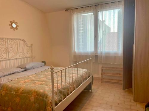 a bedroom with a bed and a window at Casa Rosa in Porto Garibaldi