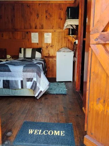 a bedroom with a bed in a wooden cabin at Buffalo Street Cottages in Malelane