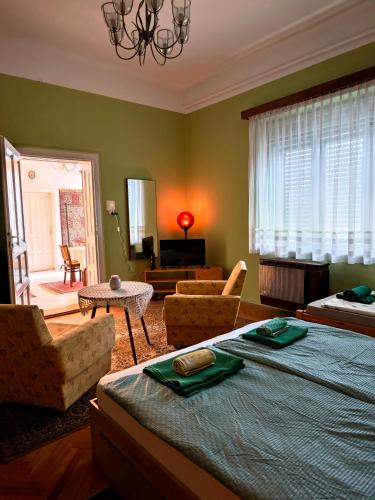 a bedroom with a large bed and a living room at Retró Kúria in Fonyód