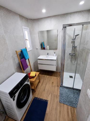 a bathroom with a shower and a washing machine at Oasis in Los Cristianos