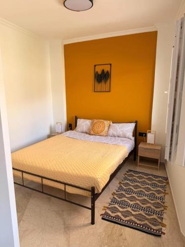 a bedroom with a bed with a yellow wall at Nature Nest in Samos